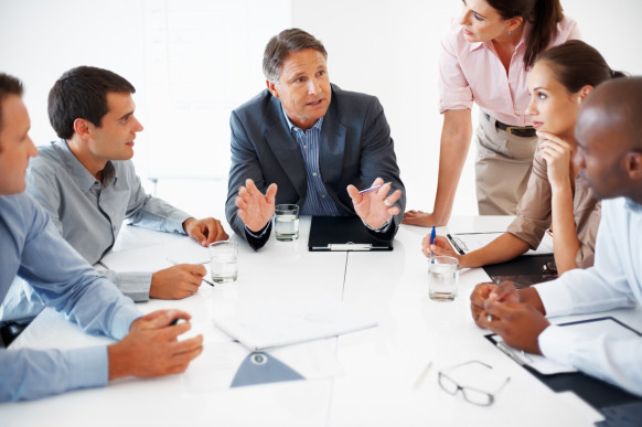 Business team listening to mature business man during meeting